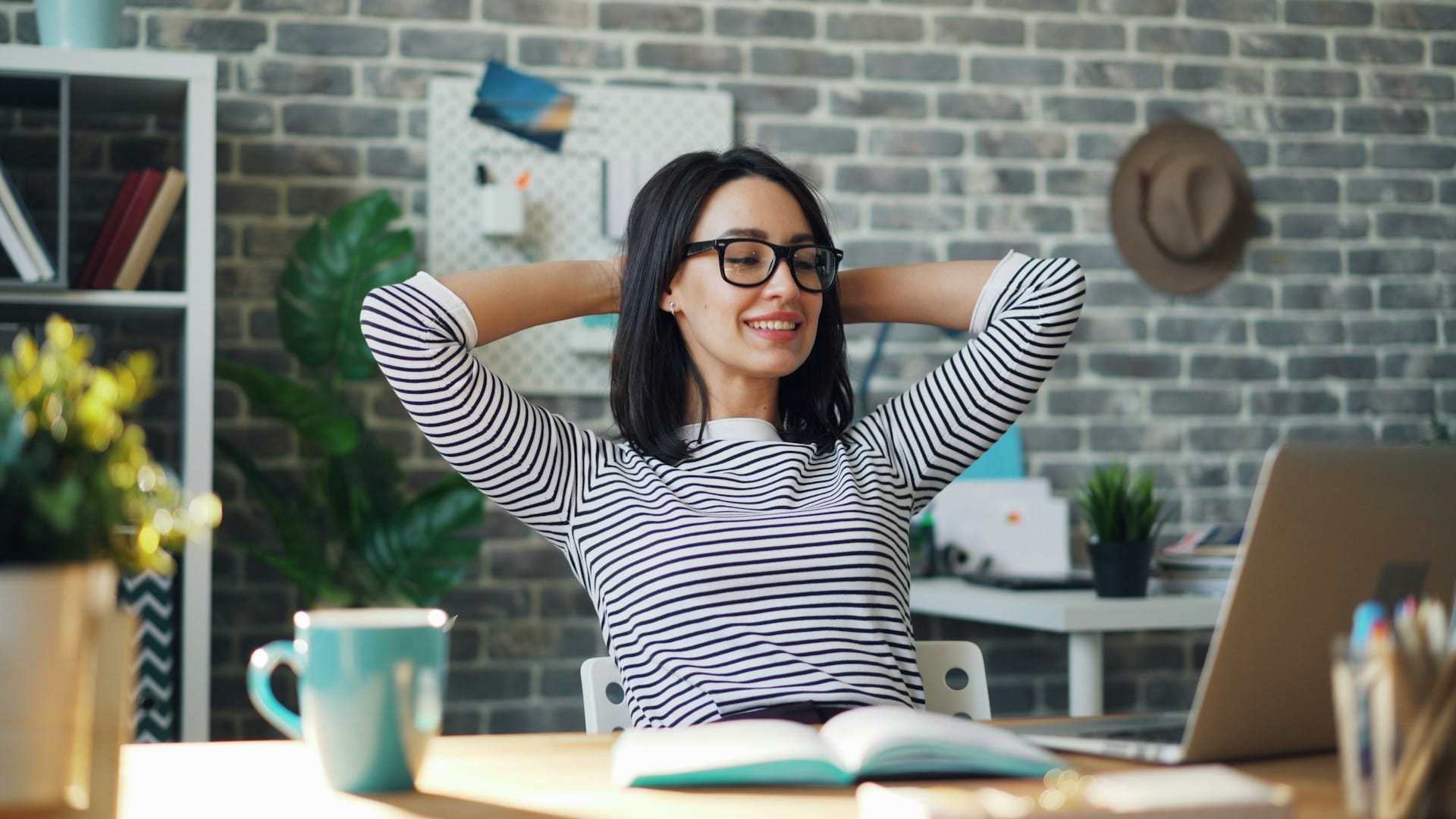 Small business owner looking relaxed at laptop with cup of coffee in a home office