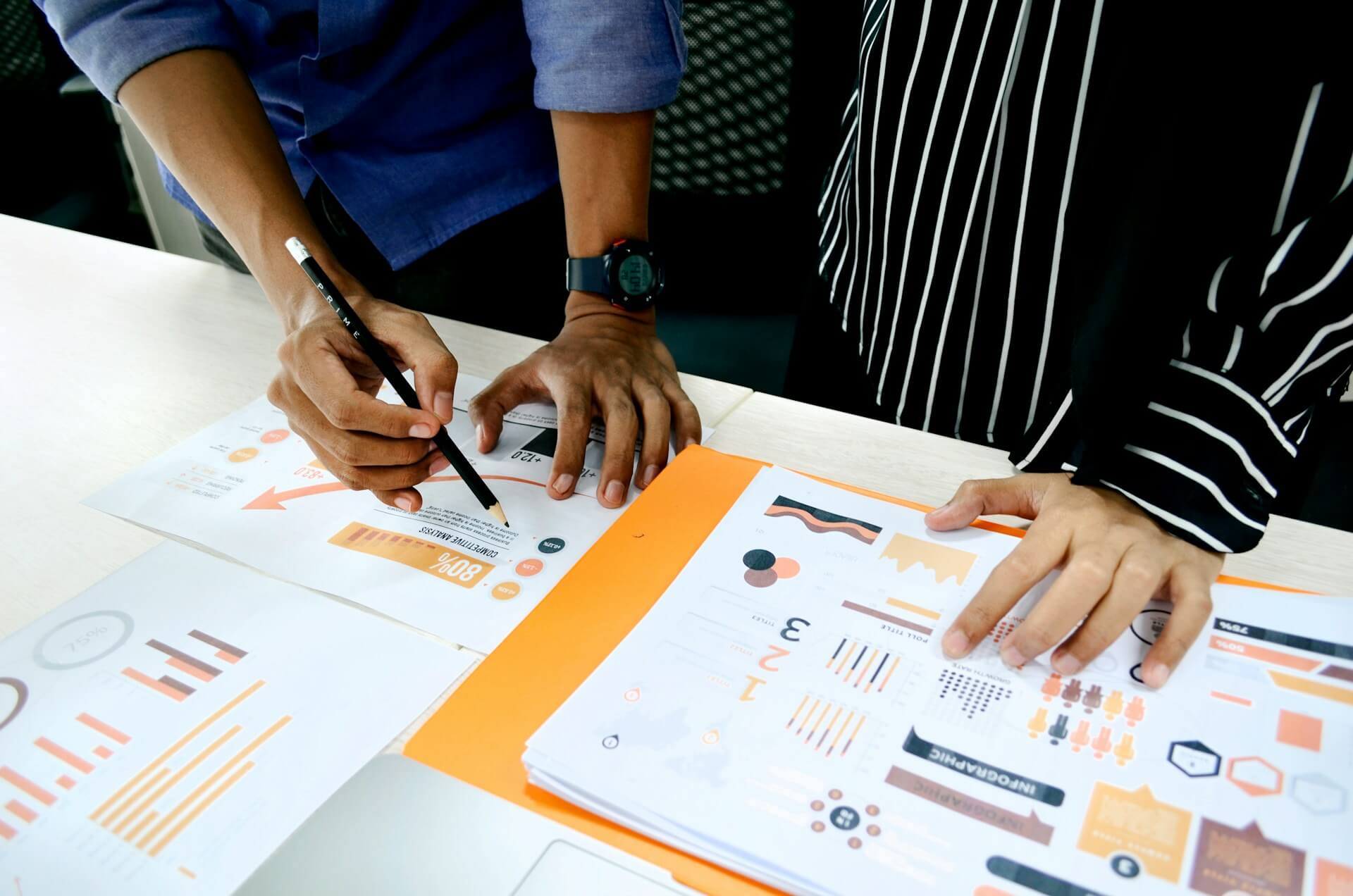 Small business owner reviewing printed brand guidelines and color samples at a studio table